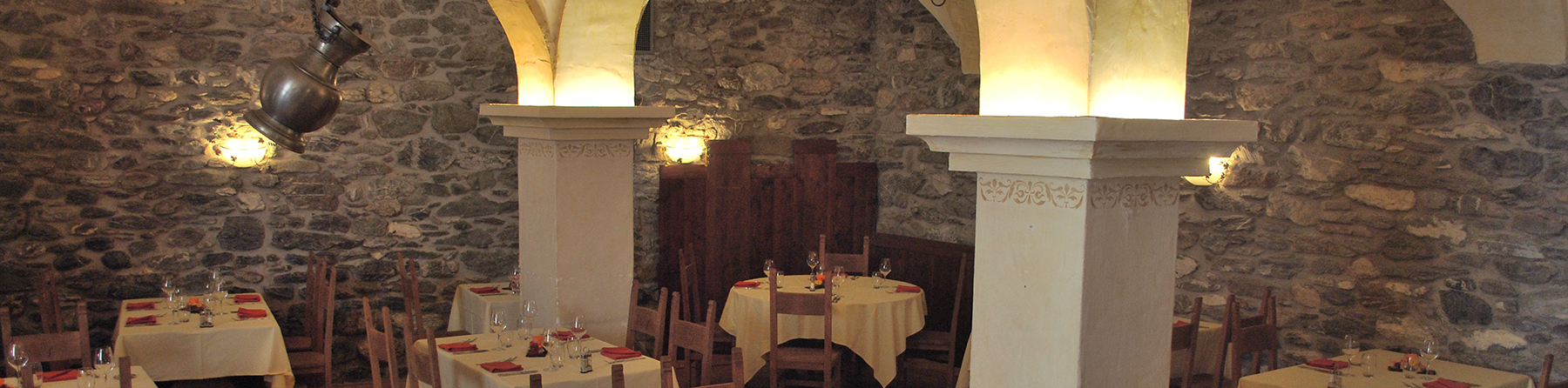 Salle voûtée aux piliers blancs et murs de pierre