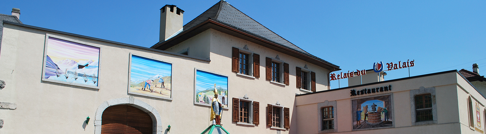 La façade du Relais du Valais et ses fresques vigneronnes